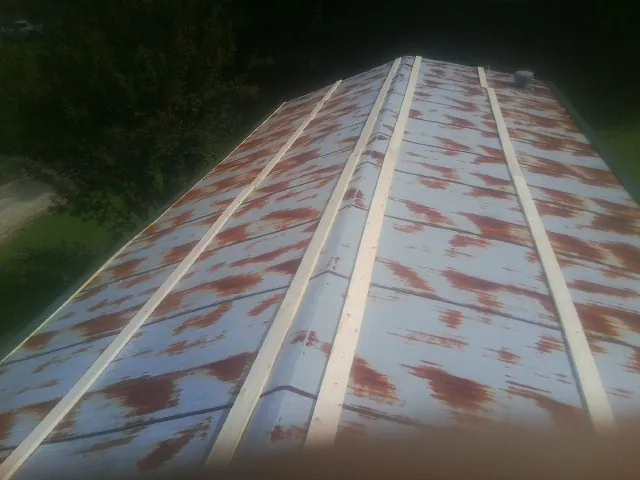 Rusted metal roof panels with new wood purlins before replacement — Storm Damage Roof Repair in Millry by Roofing Brothers